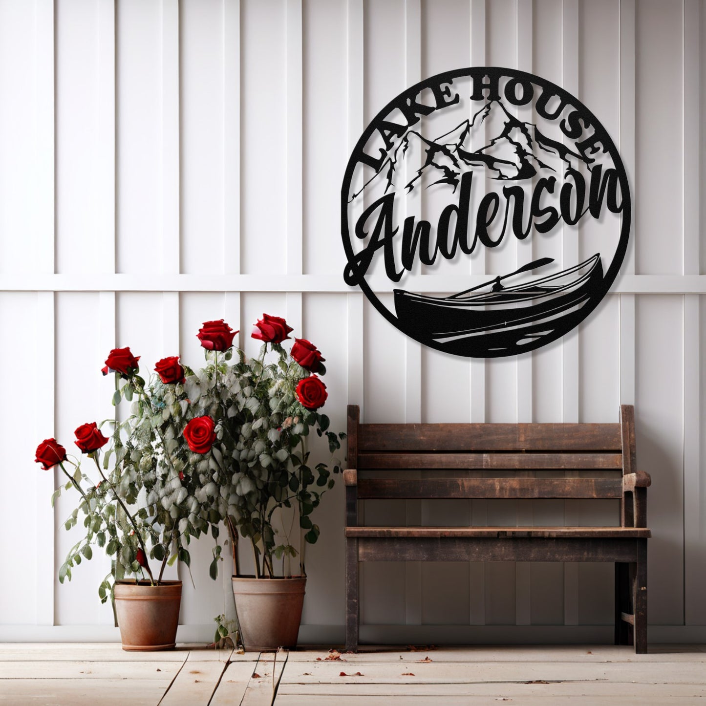 Decorative wall art with 'Lake House Anderson' design, wooden bench, and potted plants on a white paneled wall.