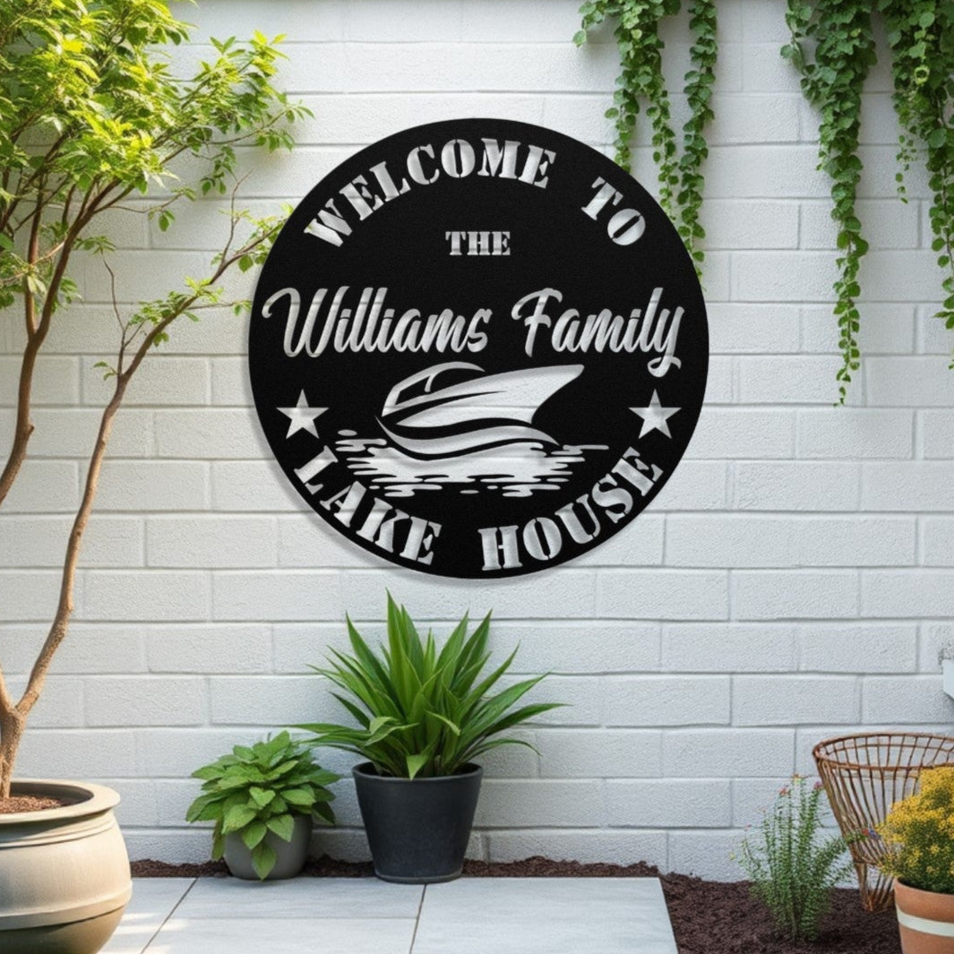 Decorative sign for 'Williams Family Lake House' on a white brick wall with plants and a bench.