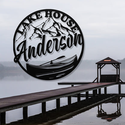 Decorative metal wall art with 'Lake House Anderson' text, mountains, and a canoe design on a white wall.